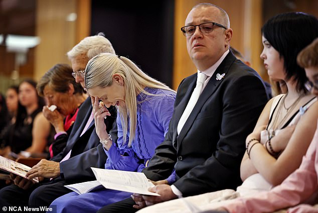 Charlotte O'Brien's mother appears crying alongside her partner at Friday's funeral.