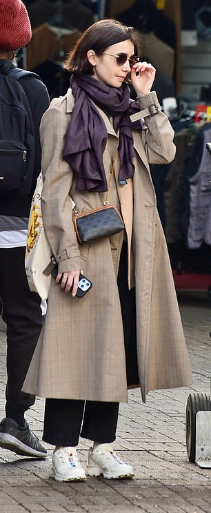 Ditching her character's bright and quirky fashion sense, the actress opted for a more understated look as she wrapped herself in the brown trench coat.