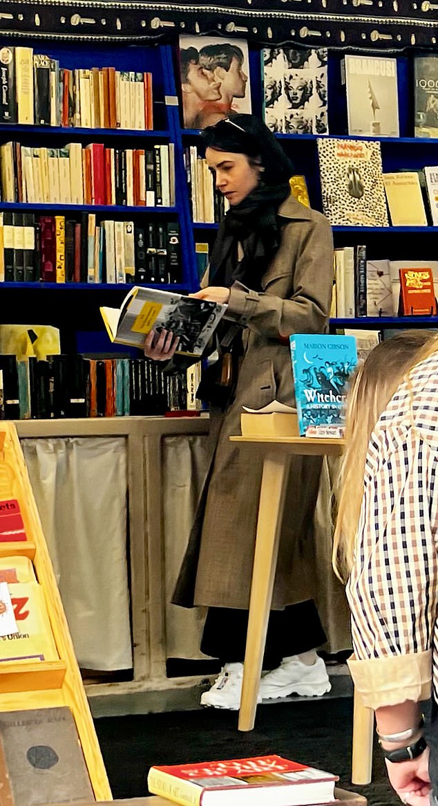 The star appeared engrossed in a book as she browsed the shelves.