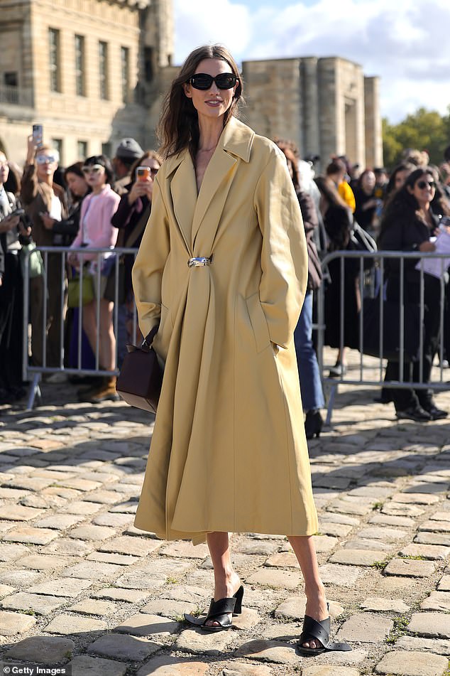 Karlie Kloss cut an effortlessly chic figure in an oversized trench coat held together with a silver brooch