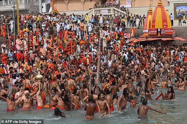 Hindu saints take a sacred dip in the waters of the Ganges during a religious ceremony in 2021