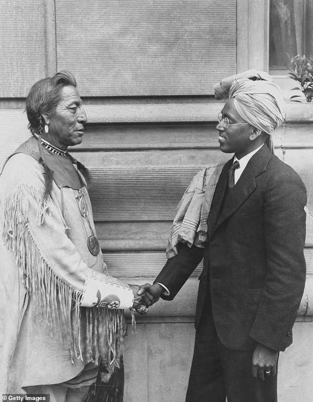 Blackfeet Native American Chief John Two Guns White Calf (1872-1934) shaking hands with A Aaron of Madras, India, as they gathered in the Twin Cities for the Rotary Convention, circa 1925.