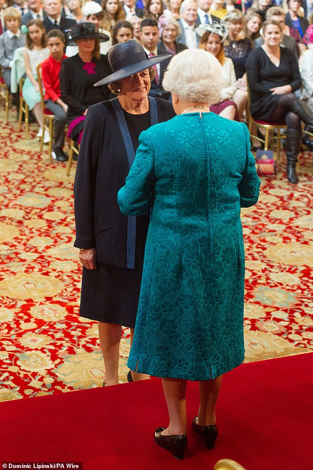 Dame Maggie Smith is appointed to the Order of the Companions of Honor by Queen Elizabeth II during an investiture ceremony at Windsor Castle on October 17, 2014.