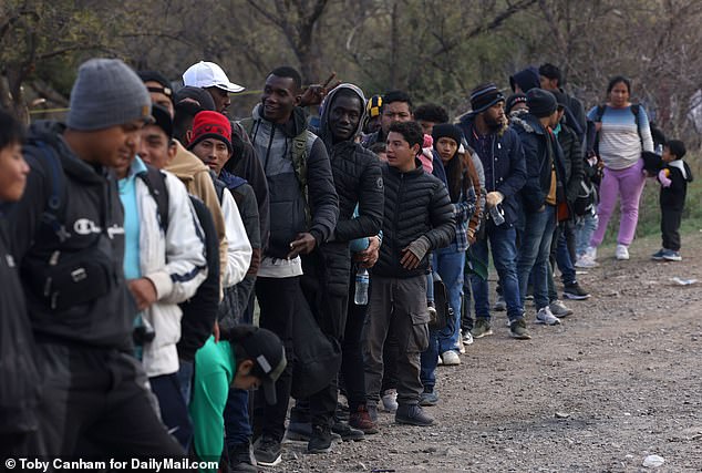 Migrants who crossed illegally into Arizona stand in line waiting to be processed by Border Patrol