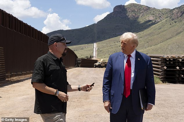 National Border Patrol Council board member Art Del Cueto walks with U.S. Republican presidential candidate and former President Donald Trump along the U.S.-Mexico border August 22, 2024 south of Sierra View, Arizona. Del Cueto told DailyMail.com that Harris created the problems at the Arizona border.