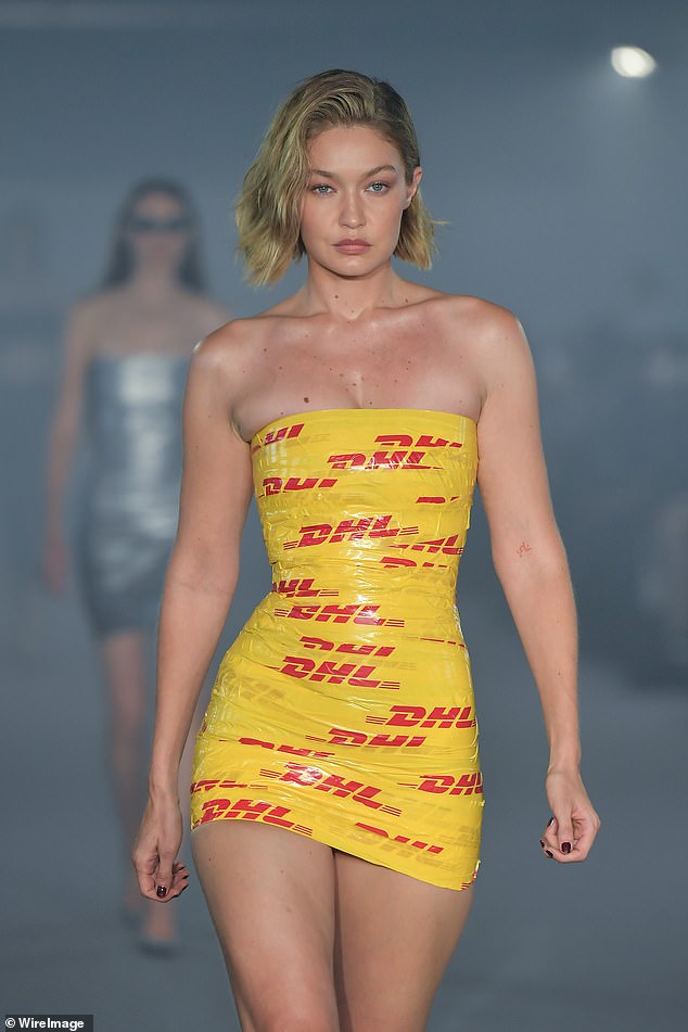 The model put on a leggy display as she walked down the runway in a short figure-hugging dress, giving the illusion that she was wrapped in yellow and red packing tape.