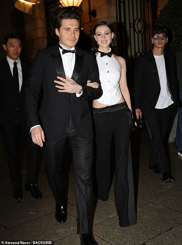 Brooklyn, 25, and his wife Nicola Peltz, 29, dressed in matching bow ties, with Brooklyn in a tuxedo suit and Ms. Peltz in a white vest and black pants.