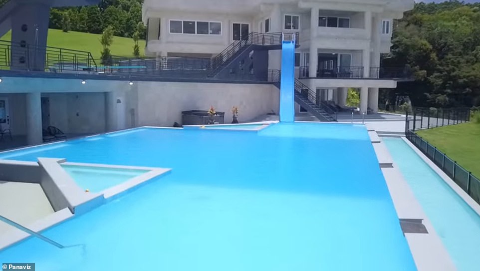 There is a huge pool with a two-story slide in the backyard.