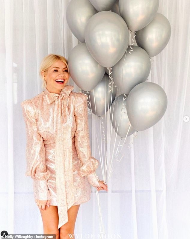 She looked stunning in a light pink leggy dress with a cute bow detail as she posed with some silver balloons.