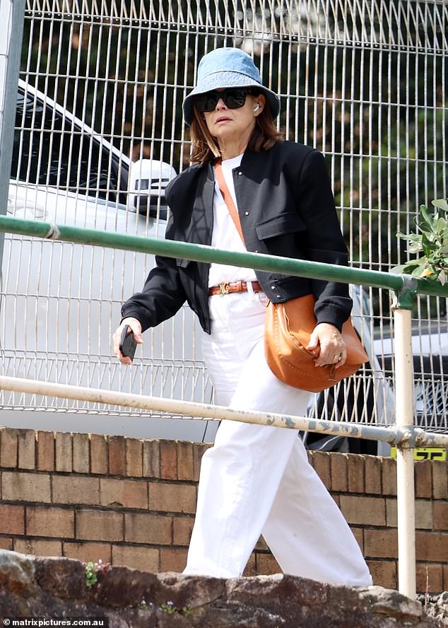 She added a pair of wide-fit white jeans and canvas sneakers for a more casual touch.