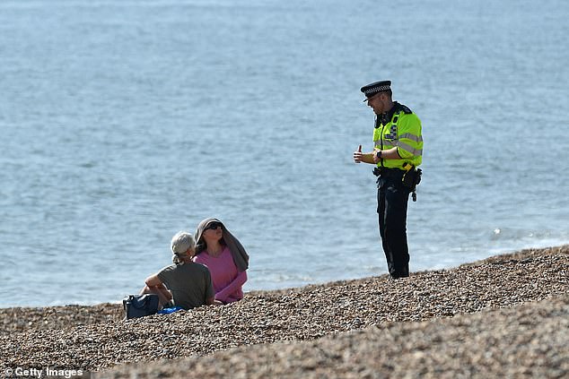 A police officer asks the public to leave Brighton beach in April 2020 as strict rules were in place.