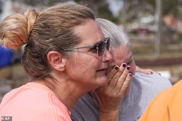 Survivors Tammy Bryan, left, hug fellow resident Jennifer Lange amid the destruction following Hurricane Helene in Horseshoe Beach on Saturday, Sept. 28.