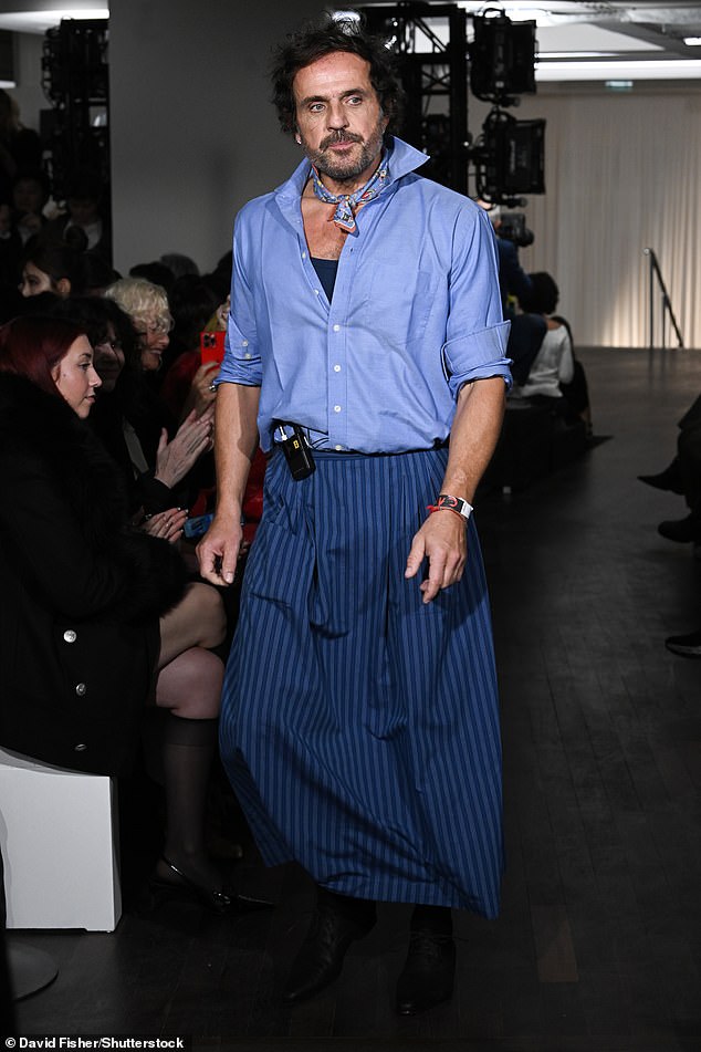 Andreas looked stylish in a blue shirt and striped skirt.