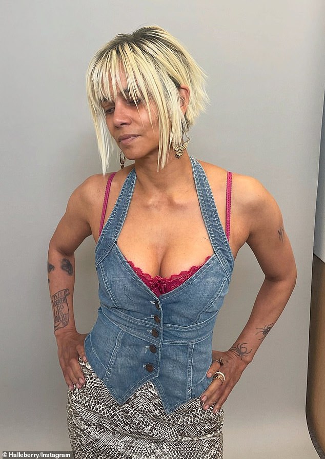 She put on a busty display in a low-cut denim top over a magenta bra.