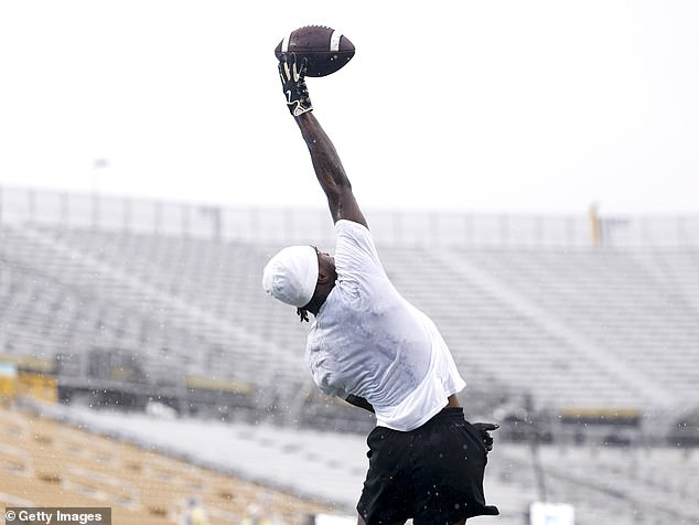 Hunter stretches to receive a pass from Shedeur Sanders during warmups Saturday in Orlando