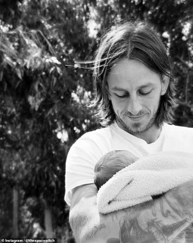 Tony Hawk's first-born son, Riley, is pictured holding his first child in his arms.