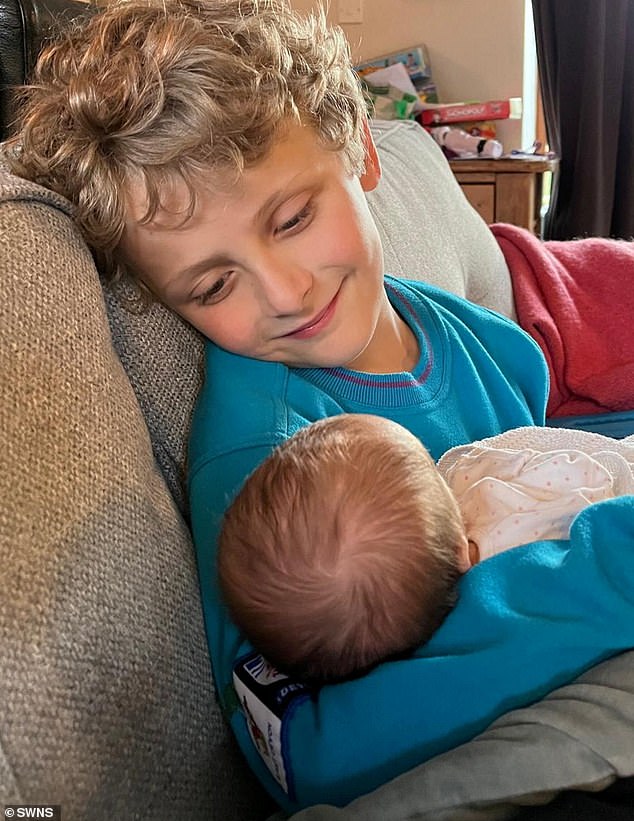 Beth's son, Thomas, holding his younger sister, Grace. The mother recalled her IVF experience: 