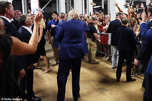 Trump hands out concessions to fans while attending the Alabama Crimson Tide vs. Georgia Bulldogs college football game.