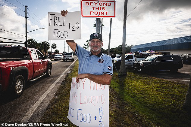 Coach Tom Goossens of Shady Hills, Florida, takes a portrait in front of the mutual aid site hosted by Shady Hills Little League in the town of Hudson.