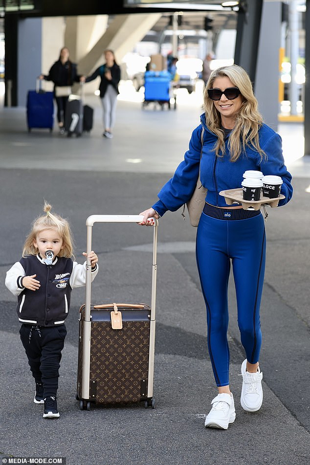 With another $4,050 Louis Vuitton bag over her shoulder, Tegan was all smiles as she guided her son Otto through the airport.