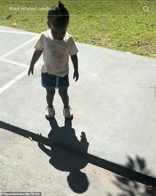 Adorable moment two year old girl tries to escape from her shadow