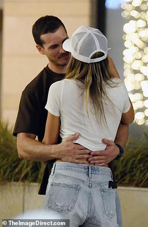 She paired a white T-shirt with low-rise shorts and double-strap sandals.