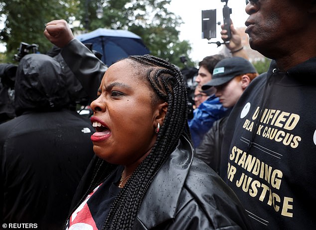 People protest as New York City Mayor Eric Adams speaks to reporters outside his official residence, Gracie Mansion, on Thursday.