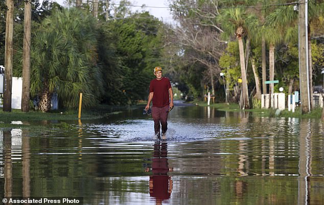 James Wilder, 55, of New Port Richey, Florida, walks through a street flooded by Hurricane Helene on Green Key Road near US 19 on Friday, September 27, 2024 in New Port Richey.