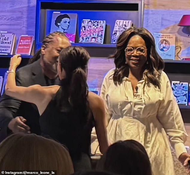 Meghan is greeted with a hug as she walks on stage at the event.