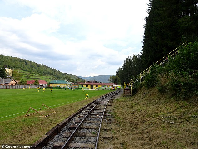 The pitch and seating terrace of the Cierny Balog Stadium (above) are crossed by a railway line.