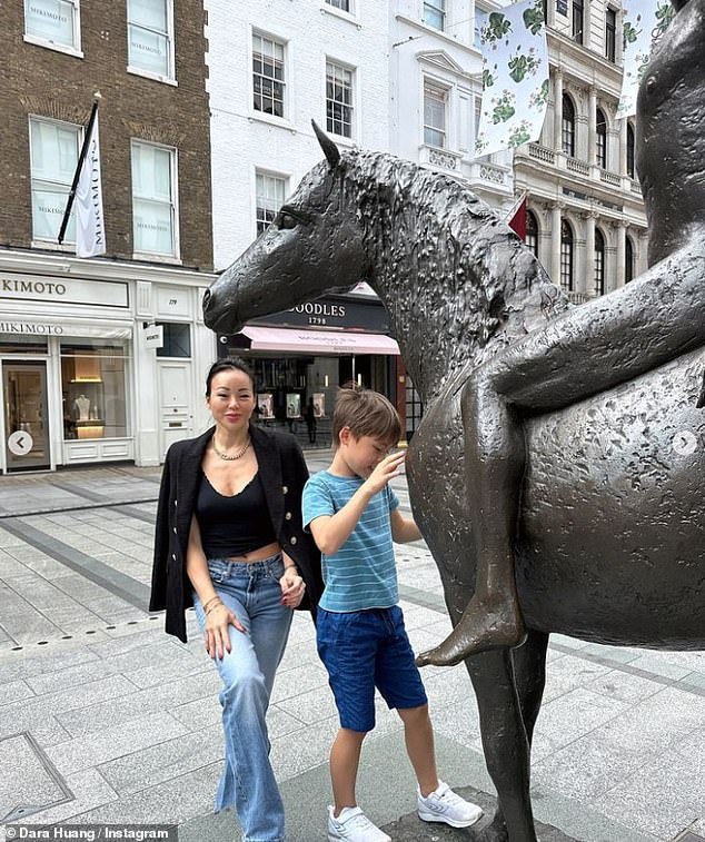 In one image, Dara, sporting a black blazer and matching vest, paired with blue jeans, posed with her son, who was dressed equally casually, next to a statue of a horse.