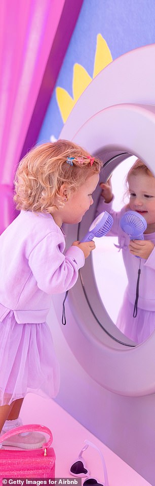 Royce photographed playing with a small handheld fan