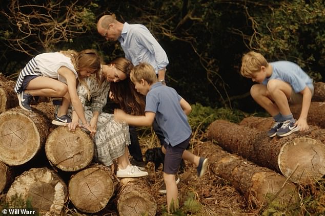 The Cambridges and their three children climb tree trunks near their home in Norfolk