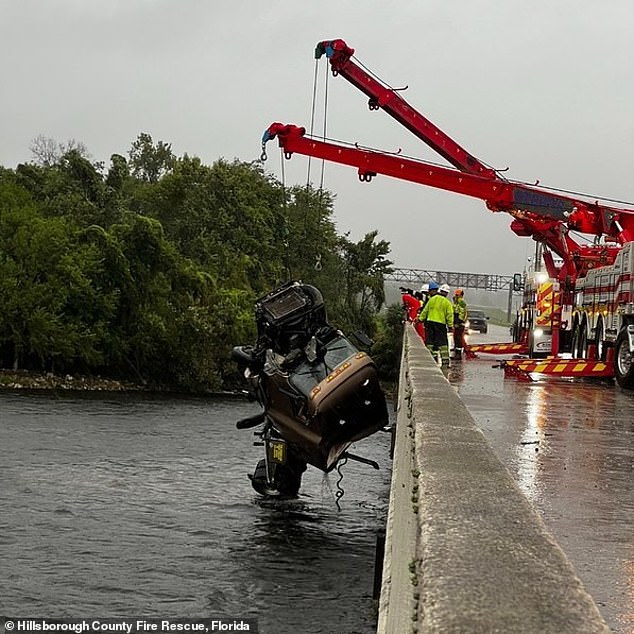 Hillsborough County Fire Rescue is seen pulling a tractor-trailer out of the water after it veered off the road following Tropical Storm Debby in August.