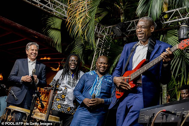 On a visit to Kinshasa in August 2022, Mutombo plays guitar as US Secretary of State Anthony Blinken (left) looks on