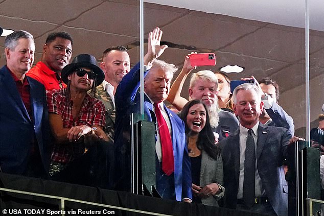 Republican presidential candidate Donald Trump waves flanked by former Georgia Bulldogs player Herschel Walker, recording artist Kid Rock, professional golfer John Daily, Alabama Senators Tommy Tuberville (R) and Katie Britt (R) during the second half of the game between Alabama Crimson Tide. and the Georgia Bulldogs at Bryant-Denny Stadium