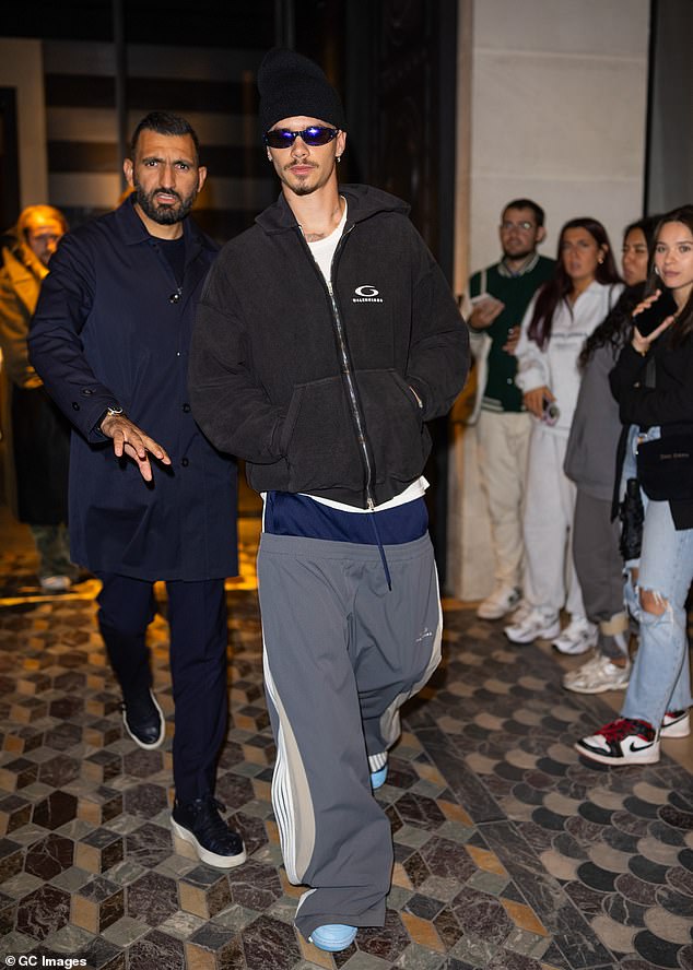 She added a plain white T-shirt and a faded Balenciaga hoodie to her sporty look and completed her ensemble with a beanie, retro sunglasses and baby blue shoes.