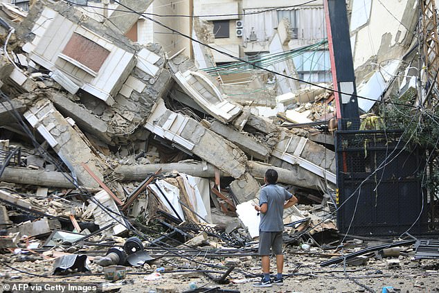 A man observes the destruction at the site of an overnight Israeli airstrike in the Ruwais neighborhood in Beirut's southern suburbs today.