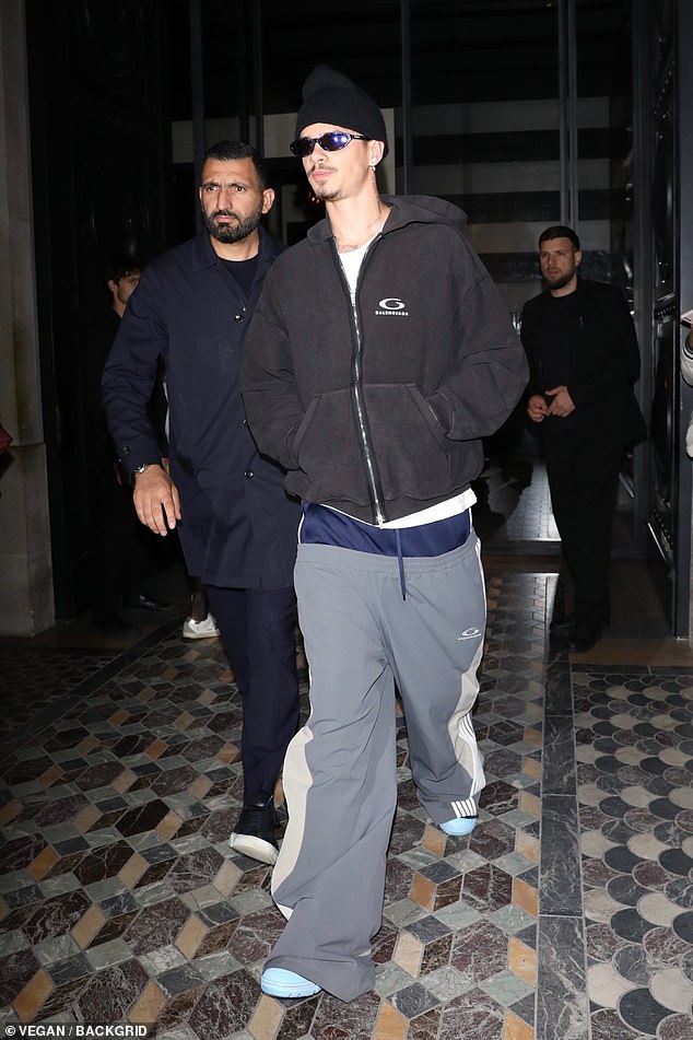 Romeo Beckham donned a pair of gray and white striped sweatpants over a pair of navy shorts for the outing.