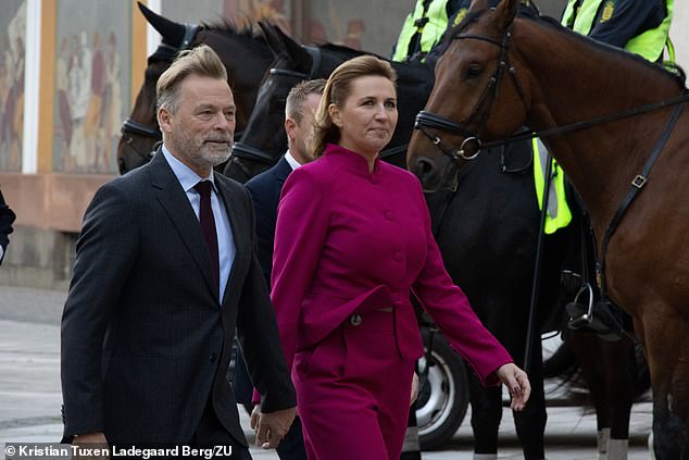 Prime Minister Mette Frederiksen (right), the youngest prime minister in Danish history, wore a dark pink pantsuit, while her husband Bo Tengberg (left) looked dapper in a dark suit and tie.