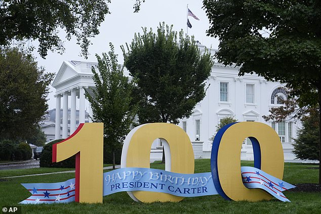 A sign wishing former President Jimmy Carter a happy 100th birthday stands on the North Lawn of the White House.