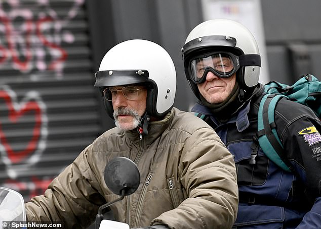 The star (left) looked completely unrecognizable while filming motorcycle scenes with actor Sean Bean in Manchester seven years after retiring.