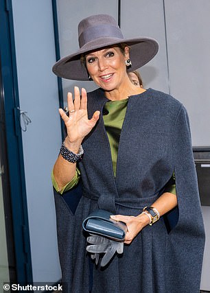 The Queen appeared in an elegant dark gray cape and matching suede hat.