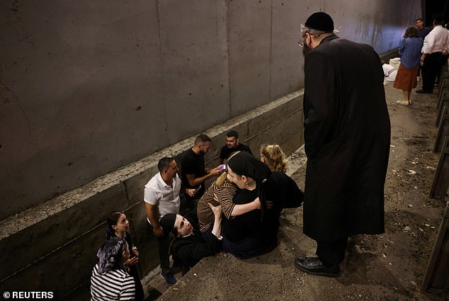 Men, women and children take shelter as air raid sirens sound across Israel