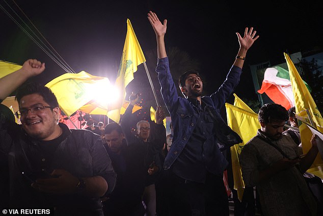 Iranians celebrate in the street after the launch of a barrage of missiles against Israel