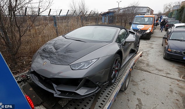 Romanian police officers take away a Lamborghini sports car belonging to Andrew Tate in January 2023.