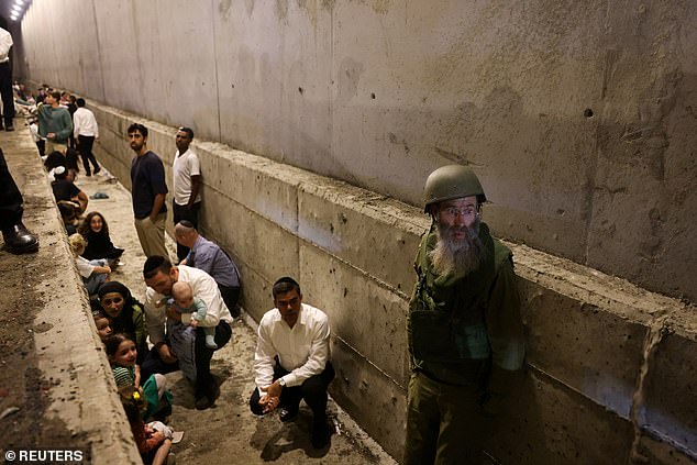 People take shelter during an air raid siren, amid cross-border hostilities between Hezbollah and Israel.