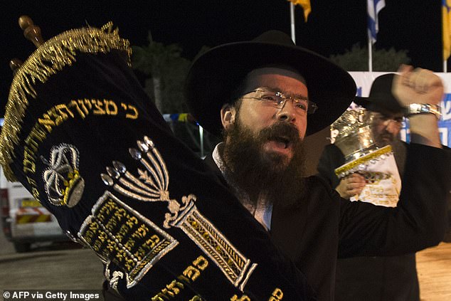 Jews dance with Torah scrolls during the Simhat Torah celebration in the Mediterranean coastal city of Netanya, north of Tel Aviv, on October 8, 2012.