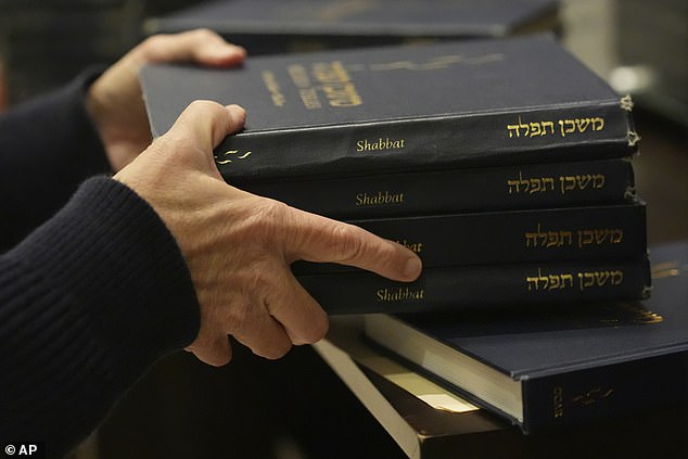 A man hands out prayer books during a Shabbat service on September 27.