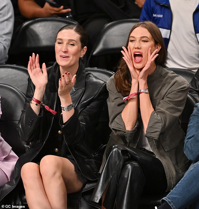 Karlie seemed in high spirits as she sat on the court with a friend cheering on the teams.